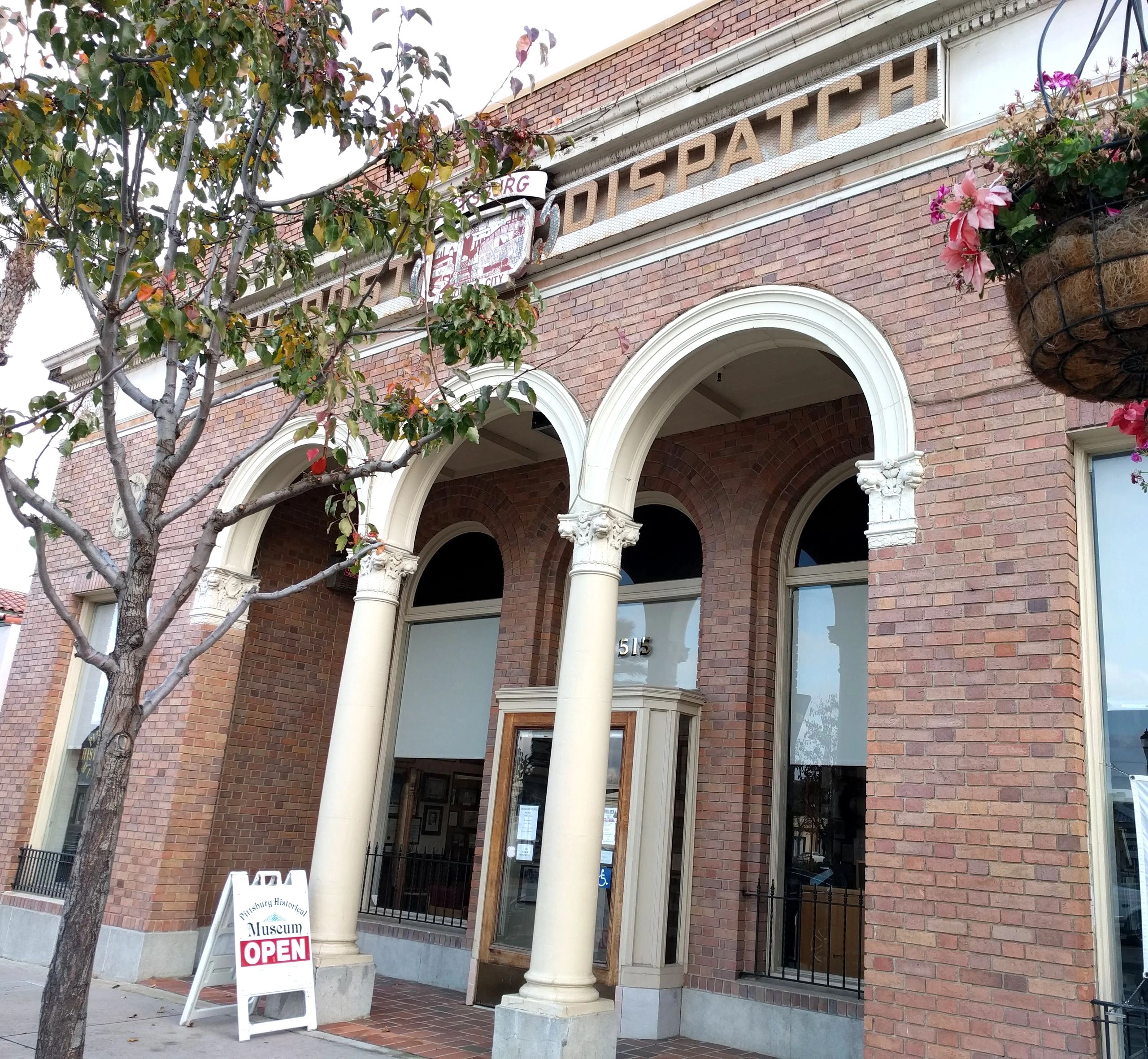 Historic brick museum building with open signage